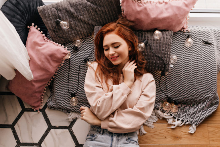 romantic girl lying gray pillows indoor photo cheerful ginger lady posing cozy room